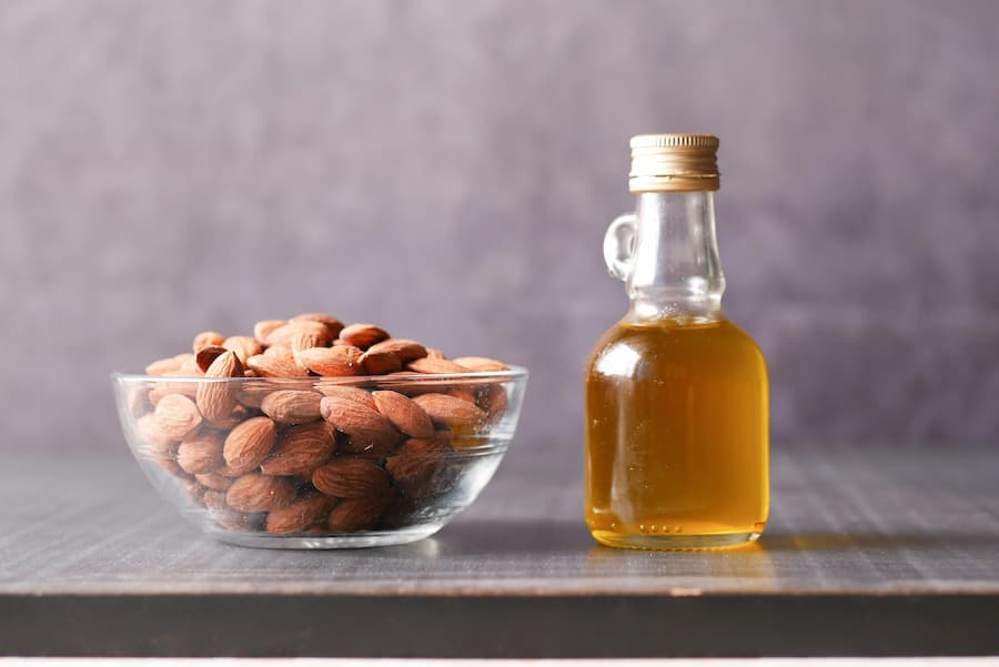 Illustration of natural sweet oil and almonds, showing a gentle approach for supporting healthy nail and skin appearance